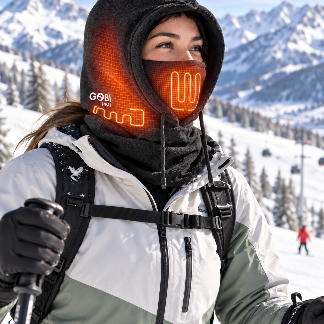 Woman wearing the Squall Heated Balaclava on an alpine slope.
