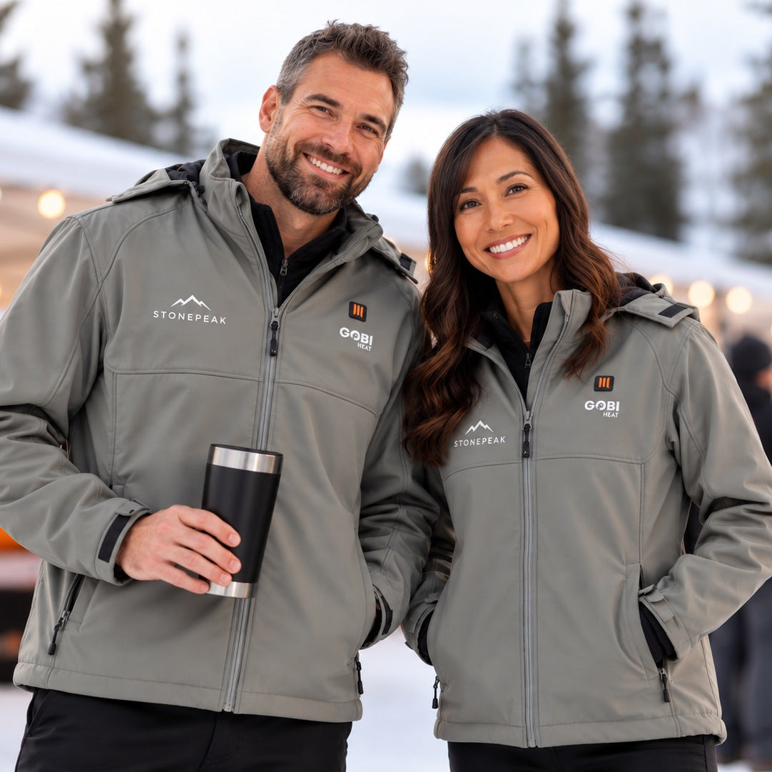Two people wearing GOBI Heat jackets at a winter event.