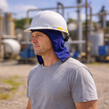Person wearing a white hard hat and blue neck gaiter in an industrial setting